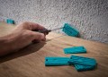 Zestaw 3 narzędzi do układania paneli laminowanych firmy Wolfcraft 6975000: łyżka dociągajaca, dobijak oraz 30 sztuk klinów dylatacyjnych 6975000